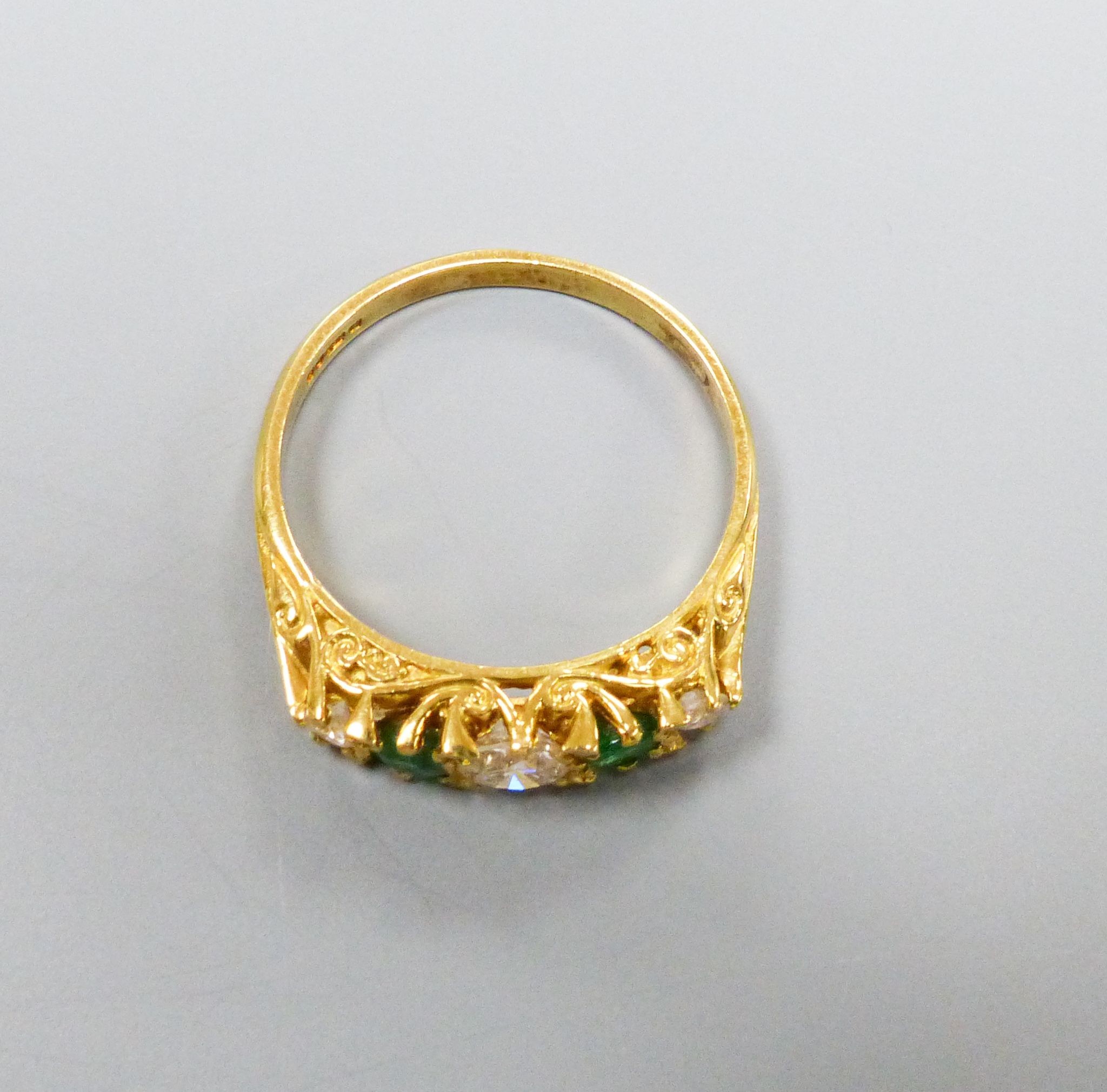 A modern Victorian style 18ct gold, three stone diamond and two stone emerald set half hoop ring, size P, gross weight 3.4 grams.